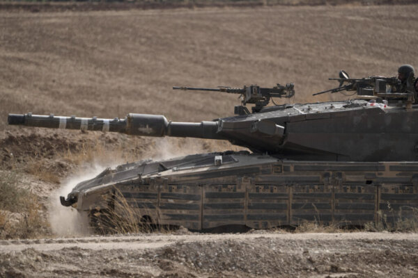 Israeli soldiers move on the top of a tank near the Israeli-Gaza border, as seen from southern Israel, Tuesday, May 28, 2024. (AP Photo/Leo Correa)